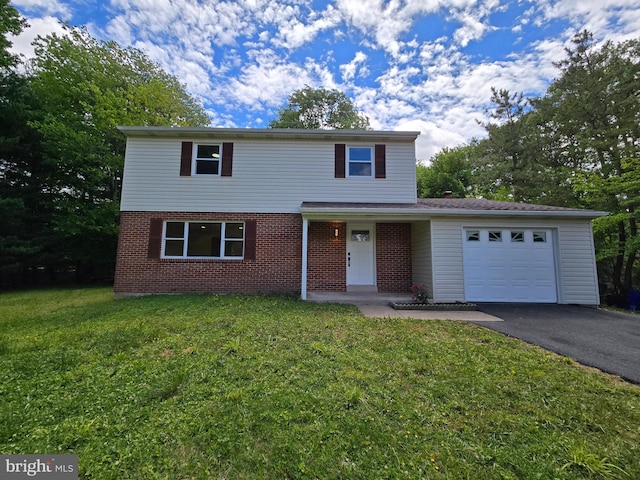 585 Andrew Dr, Southampton, PA 18966 - traditional-style home featuring asphalt driveway, a garage, a front yard, and brick siding