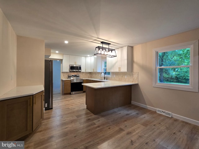 585 Andrew Dr, Southampton, PA 18966 - kitchen with stainless steel appliances, a sink, a peninsula, decorative backsplash, and light countertops