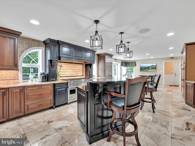 kitchen featuring luxury stove, recessed lighting, backsplash, a breakfast bar, and a center island