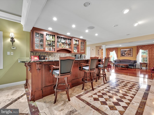 indoor wet bar featuring inlaid floor details, recessed lighting, baseboards, and decorative backsplash