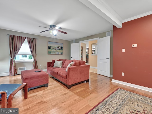 living room featuring light wood-type flooring, a ceiling fan, baseboards, and crown molding
