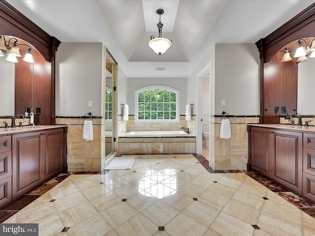 full bath with two vanities, a garden tub, wainscoting, a shower stall, and tile patterned floors