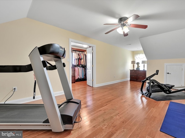 exercise area featuring lofted ceiling, ceiling fan, light wood finished floors, and baseboards