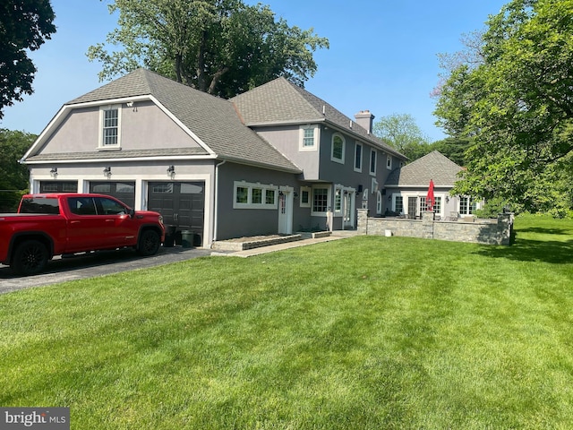 view of front of property featuring a front lawn, stucco siding, a garage, a chimney, and a shingled roof