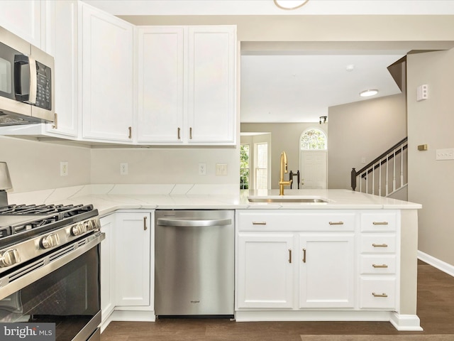 5534 Upshur, Frederick, MD 21703 - kitchen with stainless steel appliances, a sink, light stone countertops, a peninsula, and dark wood-type flooring