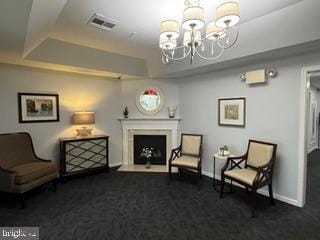 2607 Chapel Lake Dr Unit 108, Gambrills, MD 21054 - living area featuring a chandelier, carpet, a raised ceiling, a fireplace with raised hearth, and baseboards