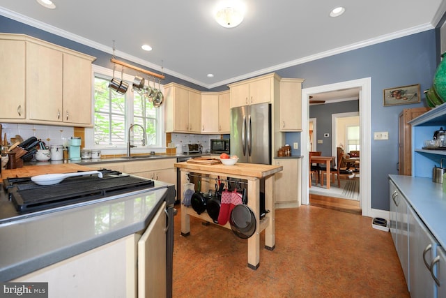 213 N Queen St, Chestertown, MD 21620 - kitchen featuring stainless steel appliances, backsplash, light brown cabinets, a sink, and crown molding