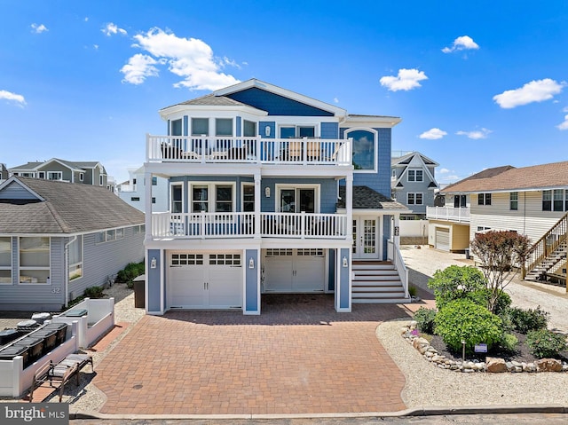 38 N 10th St, Surf City, NJ 08008 - raised beach house featuring a balcony, stairway, decorative driveway, and an attached garage