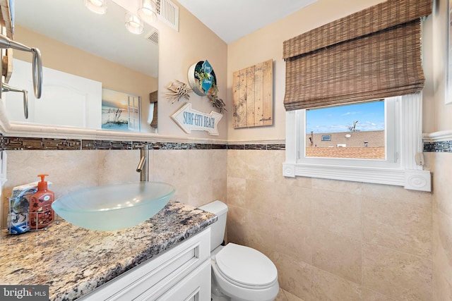 38 N 10th St, Surf City, NJ 08008 - bathroom featuring vanity, toilet, wainscoting, and tile walls