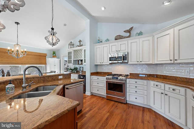 38 N 10th St, Surf City, NJ 08008 - kitchen featuring appliances with stainless steel finishes, a sink, a chandelier, decorative backsplash, and white cabinets