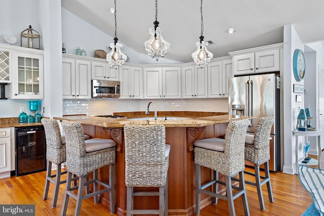 38 N 10th St, Surf City, NJ 08008 - kitchen with stainless steel appliances, beverage cooler, decorative backsplash, light wood-style flooring, and lofted ceiling