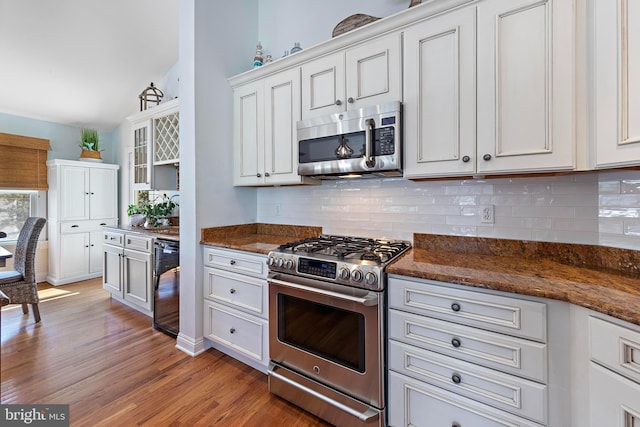 38 N 10th St, Surf City, NJ 08008 - kitchen with appliances with stainless steel finishes, light wood-style floors, decorative backsplash, and white cabinetry