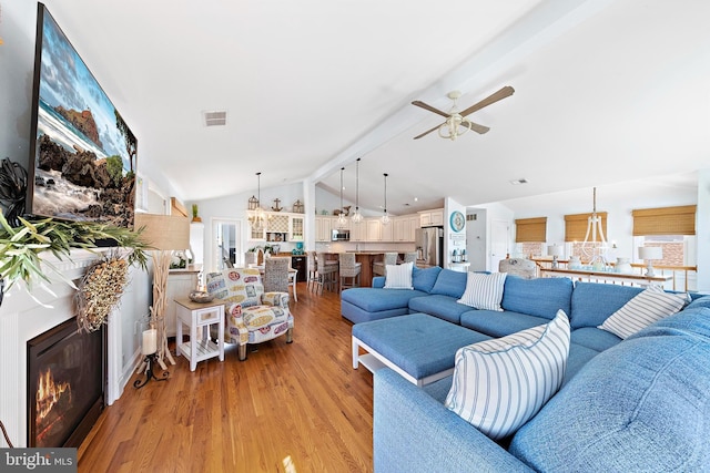 38 N 10th St, Surf City, NJ 08008 - living area featuring a chandelier, a ceiling fan, light wood-style floors, and a glass covered fireplace
