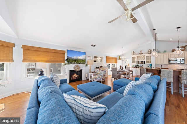 38 N 10th St, Surf City, NJ 08008 - living area featuring a ceiling fan, a chandelier, a lit fireplace, light wood-type flooring, and baseboards
