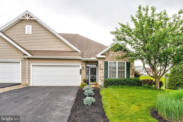 137 Settlers Way, Boalsburg, PA 16827 - view of front of house with driveway, stone siding, a front yard, a shingled roof, and a garage
