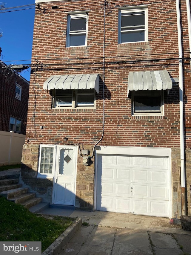 4014 Lansing St, Philadelphia, PA 19136 - view of front of house with an attached garage, brick siding, and concrete driveway