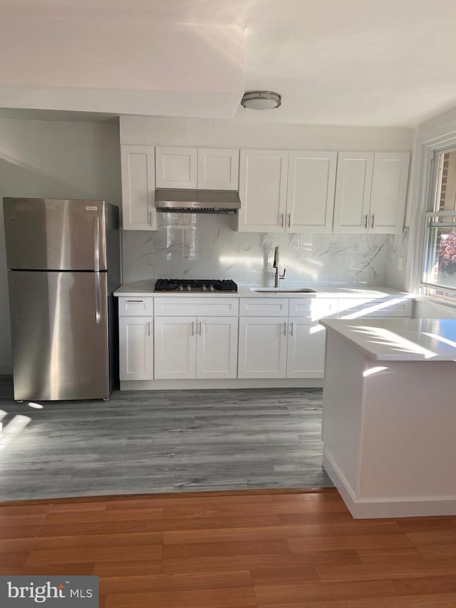 4014 Lansing St, Philadelphia, PA 19136 - kitchen featuring stainless steel appliances, a sink, under cabinet range hood, white cabinetry, and light wood-type flooring