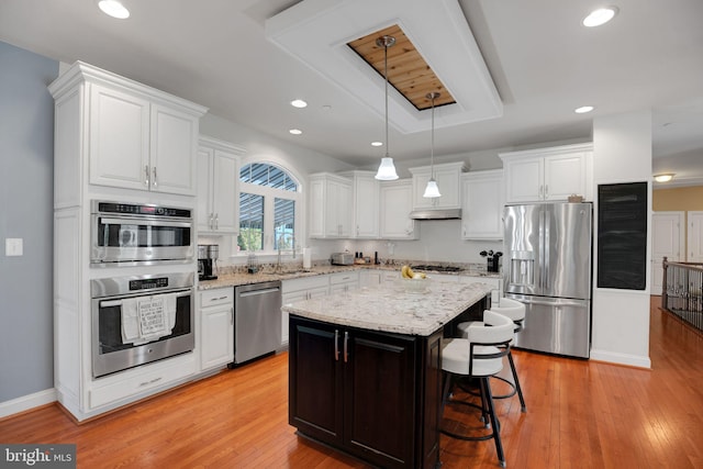 26248 Tranquility View Ct, Mechanicsville, MD 20659 - kitchen featuring appliances with stainless steel finishes, a sink, white cabinets, a breakfast bar area, and decorative light fixtures