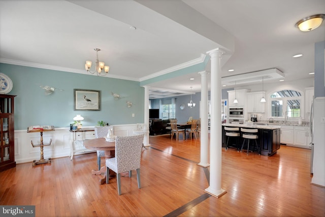 26248 Tranquility View Ct, Mechanicsville, MD 20659 - dining area with ornate columns, wainscoting, crown molding, a chandelier, and light wood-style floors