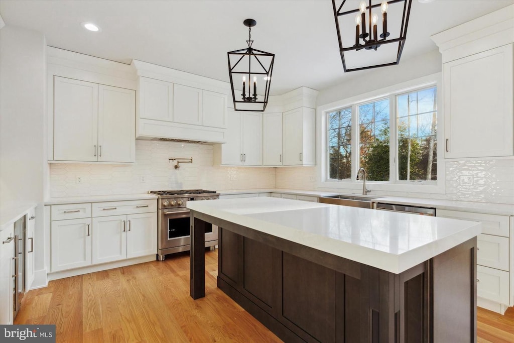 kitchen with stainless steel appliances, a sink, a chandelier, light countertops, and recessed lighting