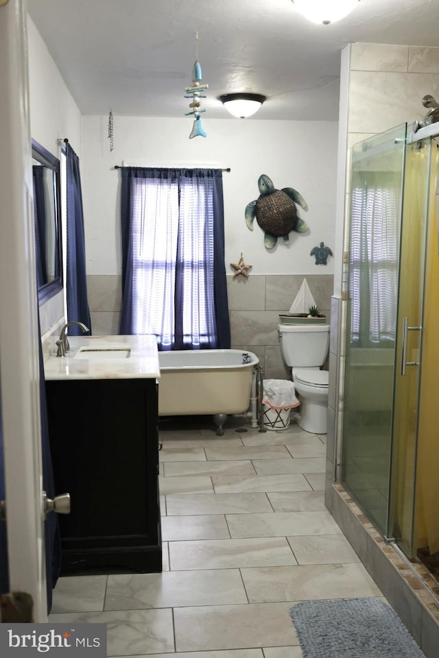 952 Moss St, Reading, PA 19604 - bathroom featuring toilet, a stall shower, vanity, tile walls, and a freestanding tub
