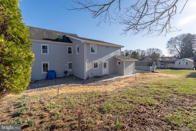 rear view of house featuring a patio and a yard