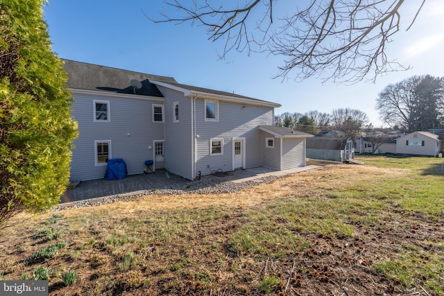 back of house with a patio area and a lawn