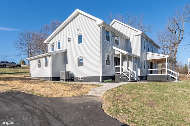 view of side of property with a porch, cooling unit, and a lawn