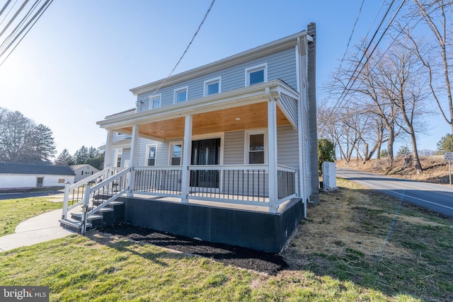 view of front of home with a porch and a front yard