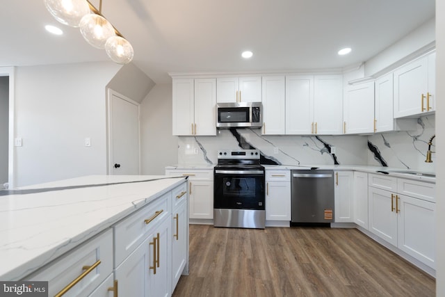 kitchen featuring appliances with stainless steel finishes, white cabinetry, backsplash, wood finished floors, and recessed lighting
