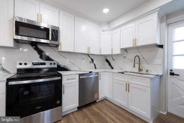 kitchen featuring stainless steel appliances, white cabinetry, dark wood-style floors, tasteful backsplash, and a sink