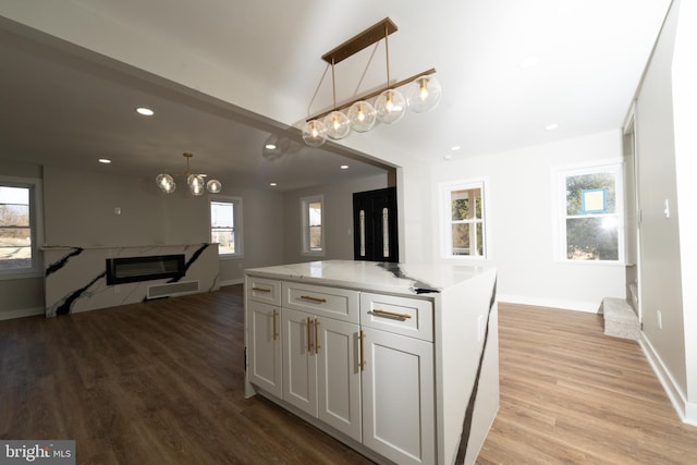 kitchen with a chandelier, light wood-style floors, recessed lighting, baseboards, and pendant lighting