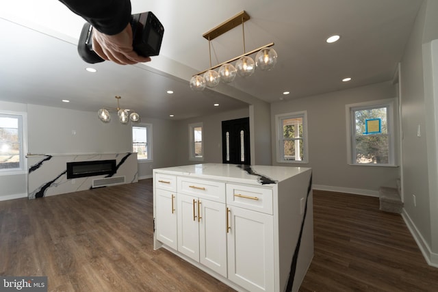 kitchen with a chandelier, white cabinets, dark wood-style flooring, baseboards, and recessed lighting