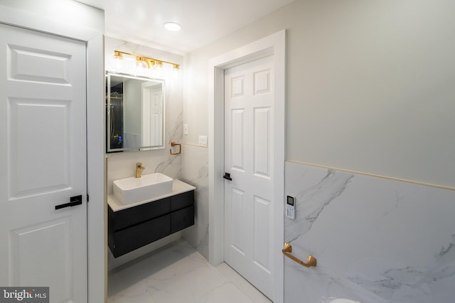 bathroom featuring marble finish flooring and vanity