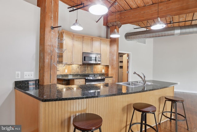 1147 N 4th St Unit 2E, Philadelphia, PA 19123 - kitchen featuring appliances with stainless steel finishes, decorative backsplash, dark wood finished floors, light brown cabinetry, and hanging light fixtures