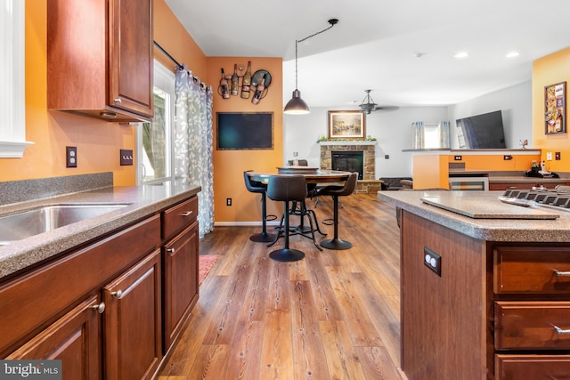 1209 Stevenage Ct, Abingdon, MD 21009 - kitchen featuring plenty of natural light, a stone fireplace, a ceiling fan, light wood finished floors, and recessed lighting