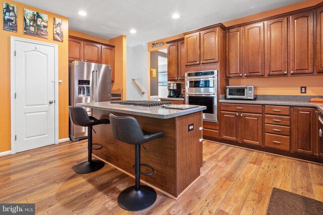 1209 Stevenage Ct, Abingdon, MD 21009 - kitchen with appliances with stainless steel finishes, a center island, light wood-type flooring, a kitchen breakfast bar, and recessed lighting