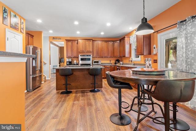 1209 Stevenage Ct, Abingdon, MD 21009 - kitchen with appliances with stainless steel finishes, brown cabinetry, recessed lighting, a breakfast bar, and light wood-style flooring