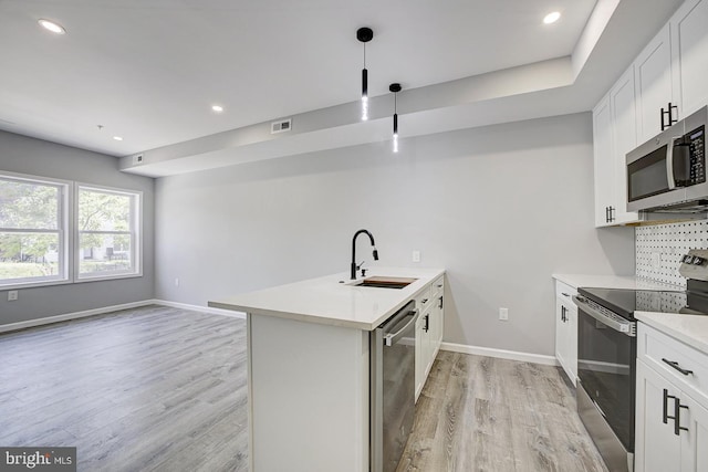 832 19th St NE Unit B, Washington, DC 20002 - kitchen featuring appliances with stainless steel finishes, a sink, a peninsula, light wood-type flooring, and light countertops