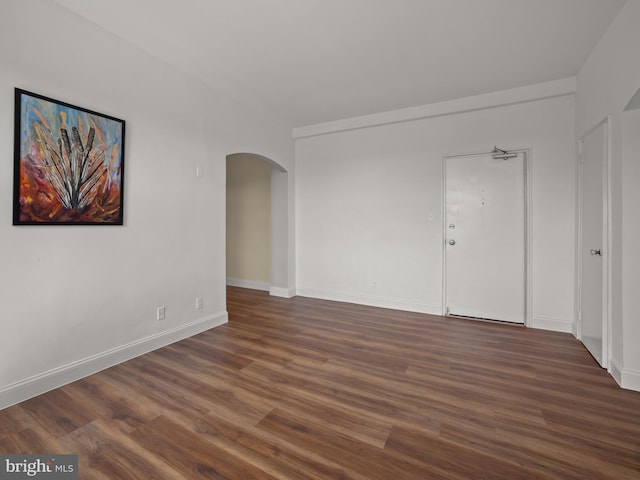 2515 K St NW Unit 807, Washington, DC 20037 - empty room with arched walkways, dark wood-style floors, and baseboards