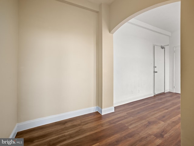 2515 K St NW Unit 807, Washington, DC 20037 - spare room with arched walkways, dark wood-type flooring, and baseboards