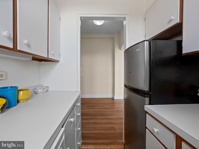 2515 K St NW Unit 807, Washington, DC 20037 - kitchen featuring freestanding refrigerator, light countertops, dark wood-style flooring, and white cabinetry