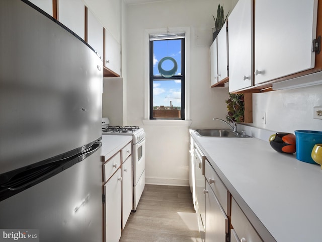 2515 K St NW Unit 807, Washington, DC 20037 - kitchen with freestanding refrigerator, white range with gas cooktop, light countertops, and white cabinets