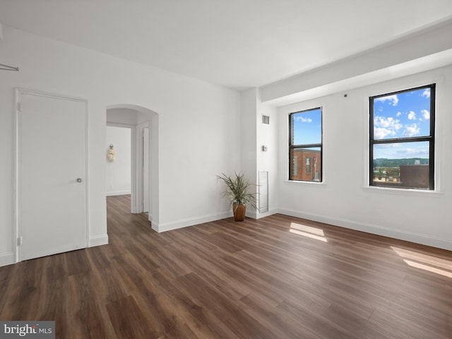 2515 K St NW Unit 807, Washington, DC 20037 - empty room with arched walkways, wood finished floors, and baseboards