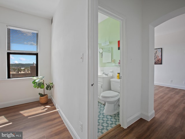 2515 K St NW Unit 807, Washington, DC 20037 - corridor featuring dark wood-style flooring, arched walkways, a sink, and baseboards