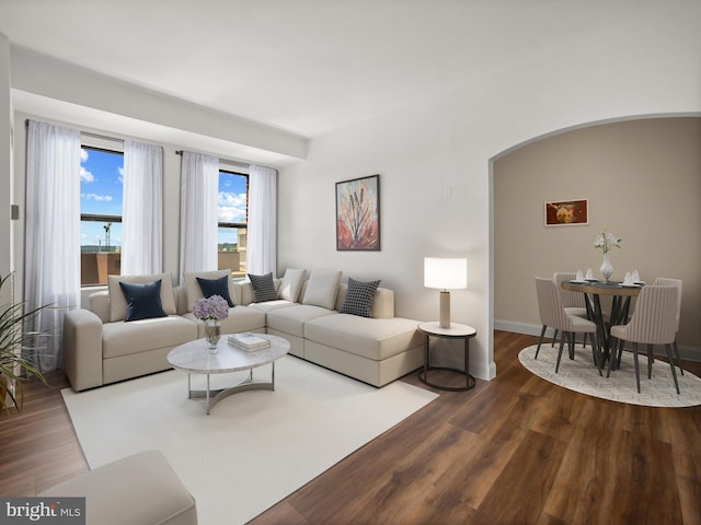 2515 K St NW Unit 807, Washington, DC 20037 - living room with dark wood-style flooring, arched walkways, and baseboards