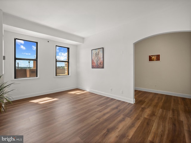 2515 K St NW Unit 807, Washington, DC 20037 - unfurnished room featuring dark wood-style floors, baseboards, and arched walkways