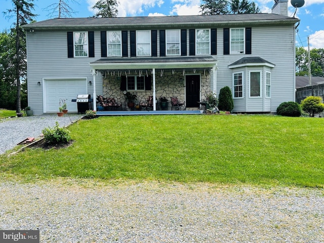99 Berkley Rd, Reading, PA 19605 - colonial house featuring a chimney, a porch, a front lawn, and an attached garage