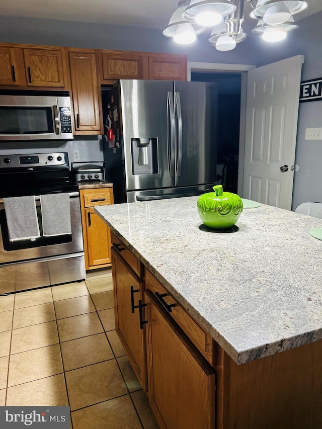 99 Berkley Rd, Reading, PA 19605 - kitchen with stainless steel appliances, light tile patterned floors, brown cabinetry, hanging light fixtures, and a chandelier