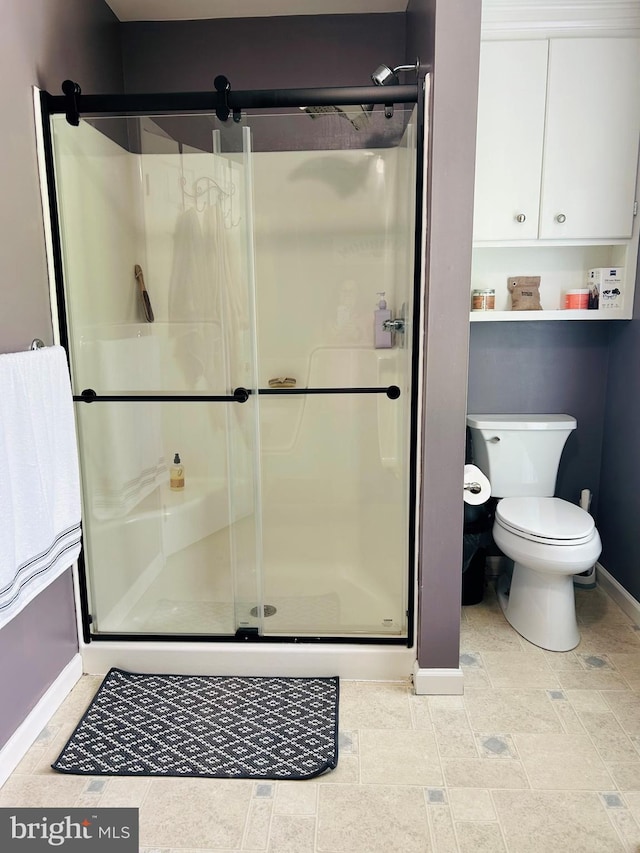99 Berkley Rd, Reading, PA 19605 - bathroom featuring baseboards, a shower stall, toilet, and stone finish floors